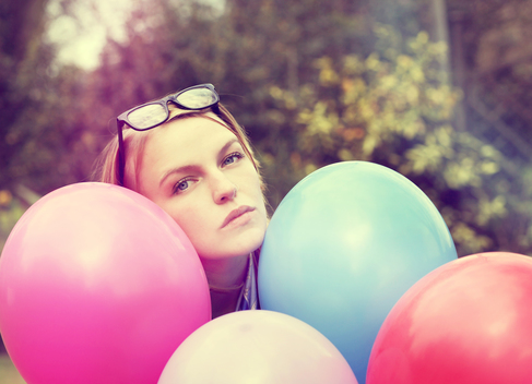 Young woman with multi coloured balloons